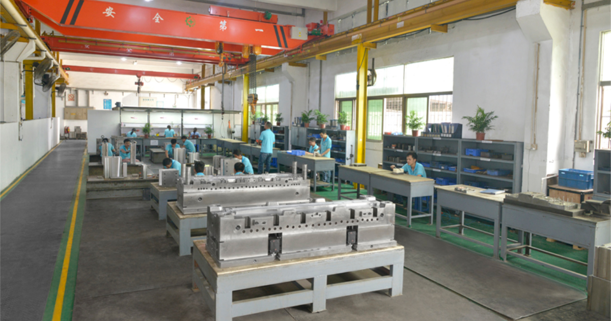 Mold assembly workstation at JBRplas Shenzhen — skilled toolmakers fitting and assembling precision injection molds