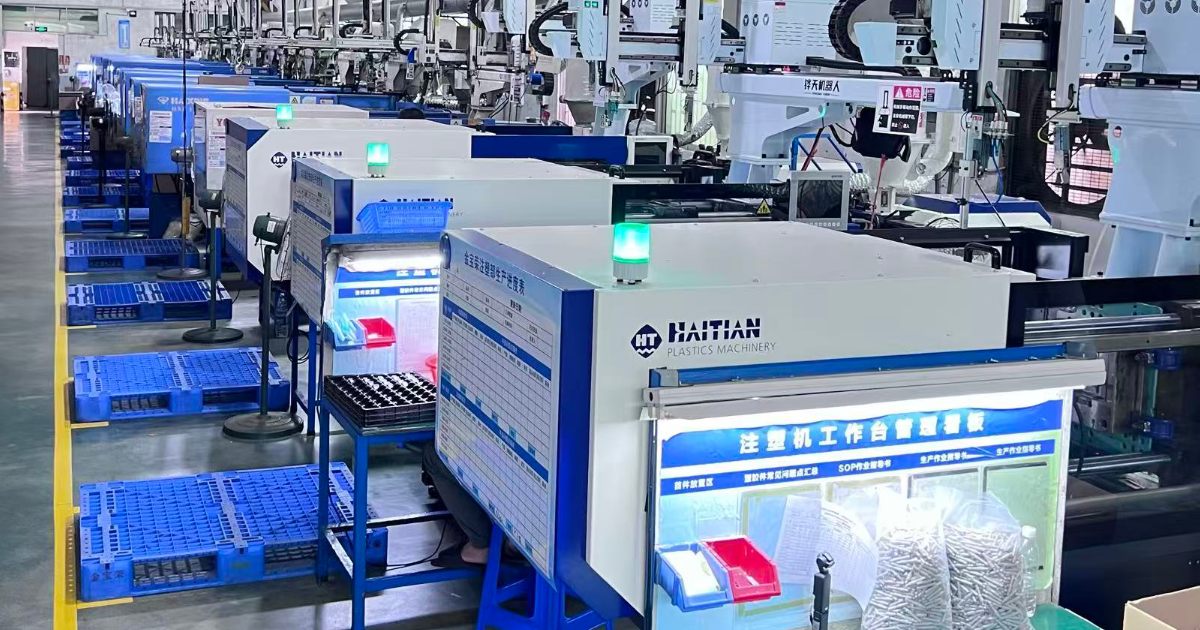 Injection molding floor — servo-hydraulic presses, automated part removal JBRplas injection molding production floor with rows of servo-hydraulic presses — Shenzhen plastic injection molding factory