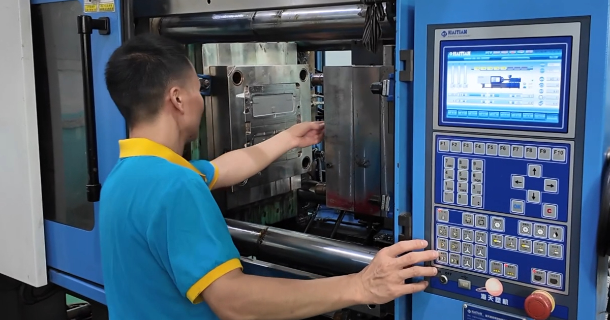 Close-up of a servo-hydraulic injection molding press showing the clamping unit and barrel — precision molding at JBRplas